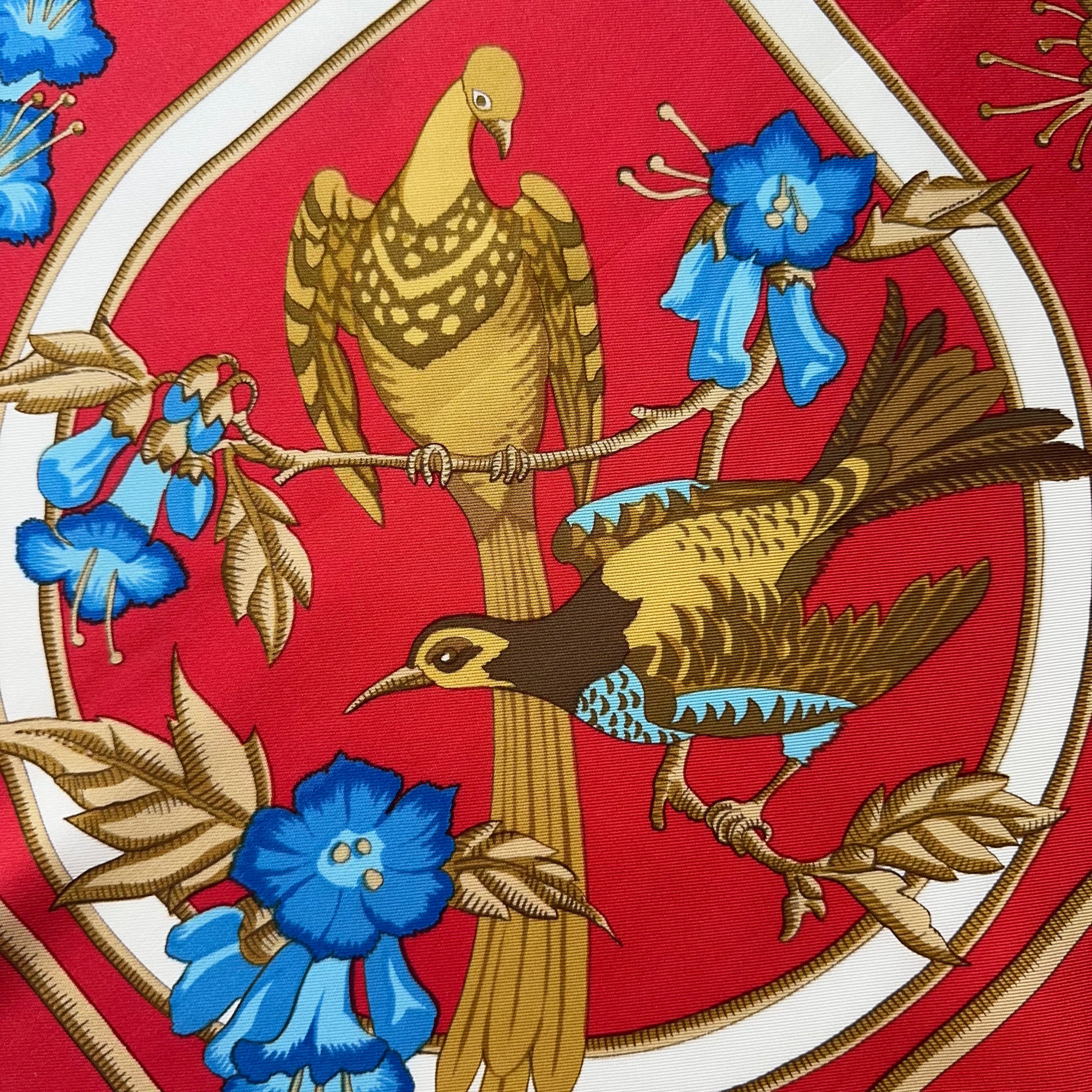 Illustration détaillée de deux oiseaux au plumage brun et or dans un médaillon circulaire sur fond rouge.