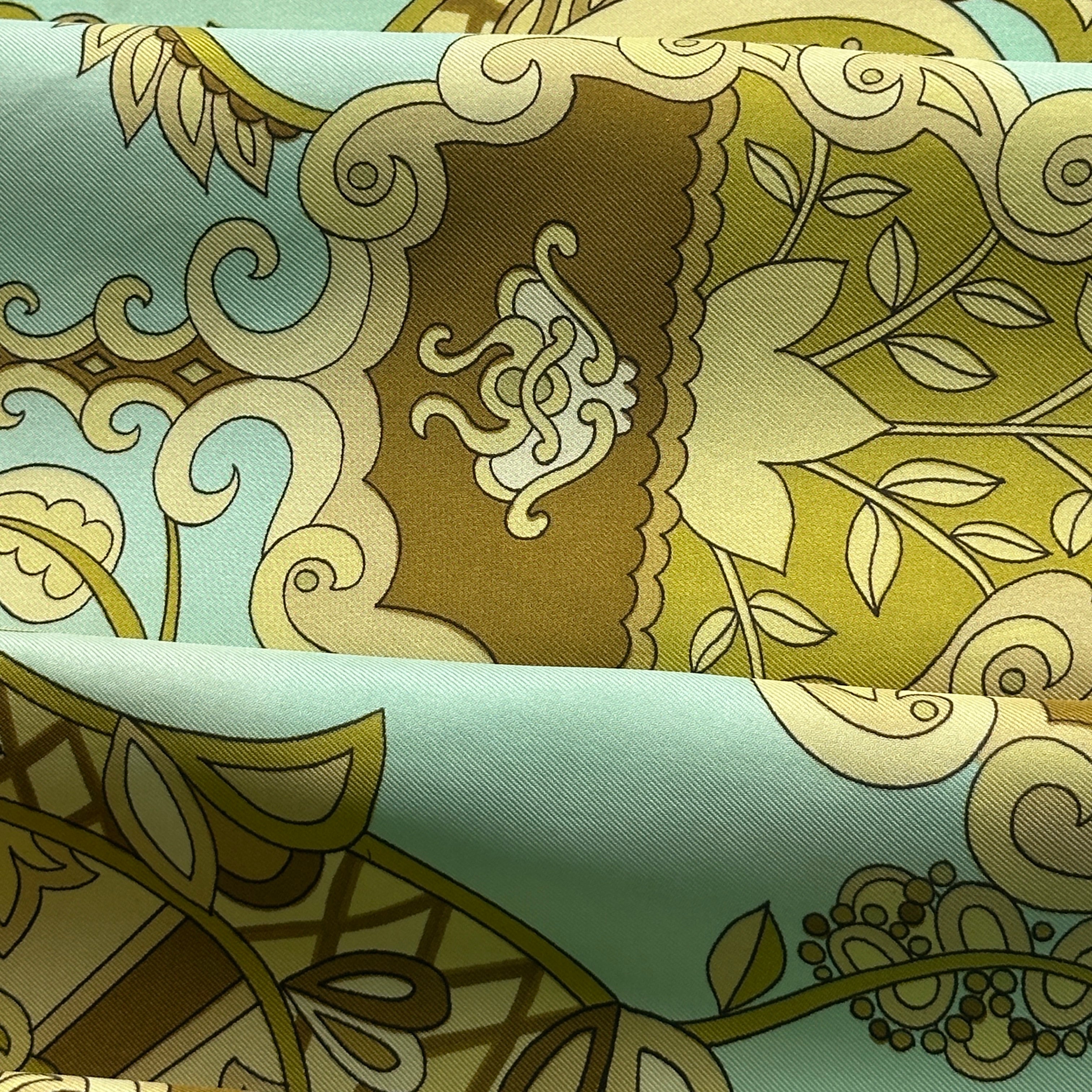 Photo de détail signalant une légère trace d'usage ou tache discrète sur le fond vert du foulard vintage.