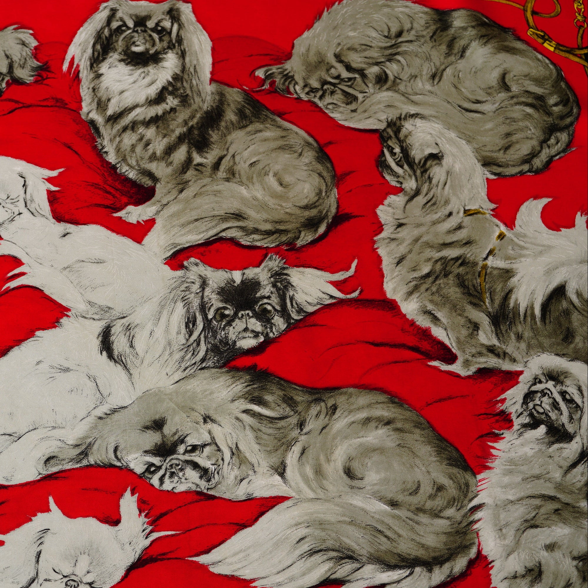 Zoom sur les illustrations de chiens royaux et cordelettes dorées du foulard Hermès Pékinois 1965.