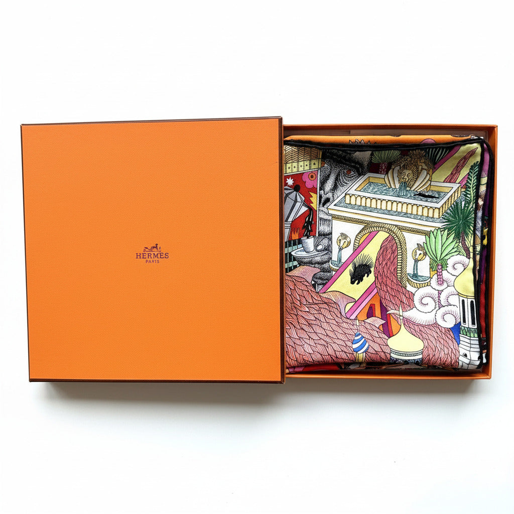Carré Hermès Animapolis avec boîte : foulard soigneusement plié dans sa boîte orange Hermès d’origine.