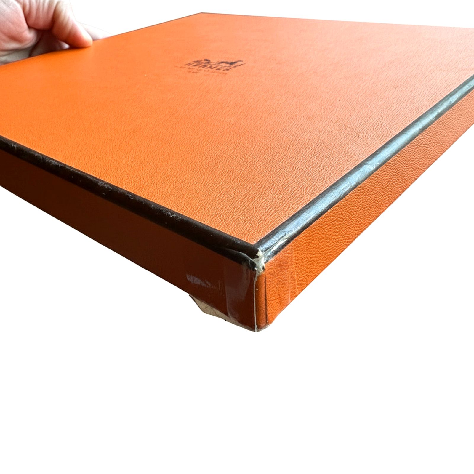 Détail de la boîte orange Hermès refermée, livrée avec le foulard Kilim